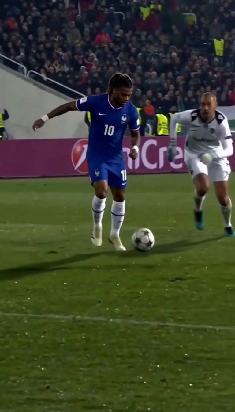 Ozil Goal AI sample: a young man with long curly hair in a blue football shirt dribbles in a packed stadium
